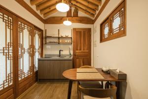 a dining room with a table and a kitchen at Luxury hanok with private bathtub - SN11 in Seoul
