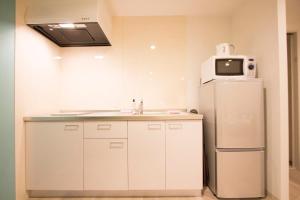 La cuisine est équipée d'un évier et d'un réfrigérateur. dans l'établissement SEVEN Building / Vacation STAY 4940, à Asahikawa