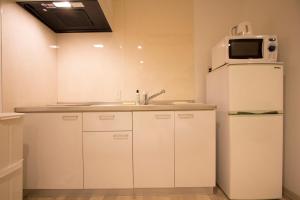 a kitchen with a white refrigerator and a microwave at SEVEN Building / Vacation STAY 4960 in Asahikawa