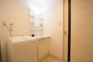 baño pequeño con lavabo y lavadora en SEVEN Building / Vacation STAY 4945, en Asahikawa