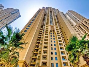 ein hohes Gebäude mit Palmen davor in der Unterkunft JBR The walk Rimal 6 - 3 Bedroom plus maid 2m walking to beach in Dubai