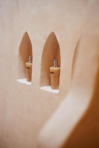two brown urinals in a wall with arches at The Oasis Bali in Canggu