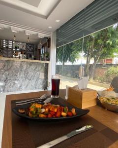 une assiette de légumes sur une table avec une boisson dans l'établissement Three Angels Lodge & Restaurant, à Chitwan