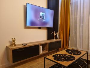 a living room with a flat screen tv on a wall at Apartament Loft KB-Ściegiennego (garaż, centrum) in Kielce