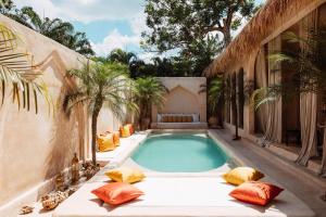an outdoor swimming pool with pillows and a swimming pool at The Oasis Bali in Canggu