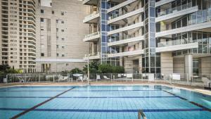 an empty swimming pool in a building with tall buildings at Luxury 2 BR Apt w Pool & Panoramic View by Sea N' Rent in Tel Aviv
