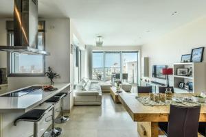 een keuken en een woonkamer met een groot raam bij Luxury 2 BR Apt w Pool & Panoramic View by Sea N' Rent in Tel Aviv