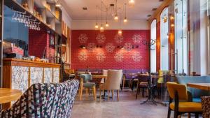 a restaurant with tables and chairs and a red wall at Optima Dworzec Lviv in Lviv