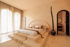 a bedroom with a white bed with a large window at The Oasis Bali in Canggu
