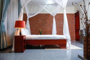 a bedroom with a canopy bed with a lamp at Fred and Winnie BnB in Kampala