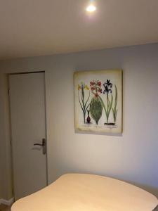 1 dormitorio con una foto de flores en la pared en Cambrai:exceptionnel studio en Cambrai