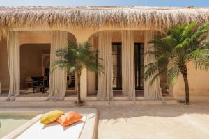 een resort met een bed en palmbomen en een zwembad bij The Oasis Bali in Canggu