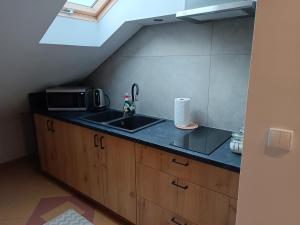 a kitchen with a sink and a microwave at Restauracja Rozmarzyn in Ostrzeszów