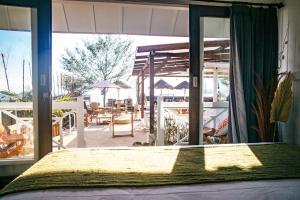 a bedroom with a bed and a view of a patio at The High Dive Gili Gede by Ultimate Resorts in Gili Gede