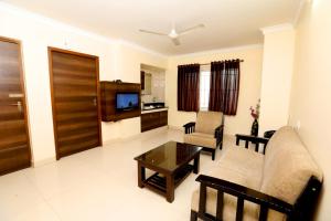 a living room with a couch and a table at Chetinaad Courtyard Gandhipuram by Centre Park in Coimbatore