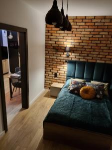 sypialnia z łóżkiem i ceglaną ścianą w obiekcie Apartament Loft KB-Ściegiennego (garaż, centrum) w Kielcach