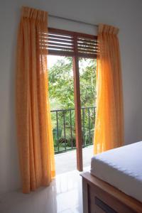 a bedroom with a bed and a large window at Sanmi Airport Resort in Katunayaka