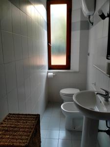 a bathroom with a toilet and a sink and a window at Casa Lucia in Rosignano Solvay
