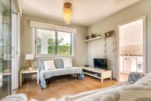 ein Wohnzimmer mit einem Sofa und einem TV in der Unterkunft Las Violetas in Arenal d'en Castell