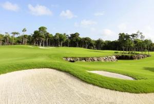 Una vista de un campo de golf con un green en Charming Apartment within Bahia Principe 5*, en Akumal