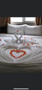 a bed with two swans making a heart on it at Sao Mai in Hoi An