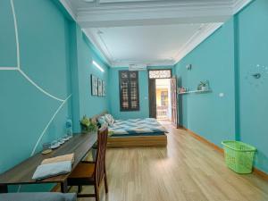 a bedroom with blue walls and a bed and a table at Amazing stay-homestay, quiet and cozy place LTT Thanh Xuân in Hanoi