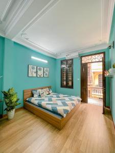 a bedroom with a bed in a blue wall at Amazing stay-homestay, quiet and cozy place LTT Thanh Xuân in Hanoi