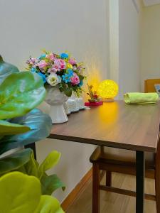 une table avec un vase de fleurs sur elle dans l'établissement Amazing stay-homestay, quiet and cozy place LTT Thanh Xuân, à Hanoï