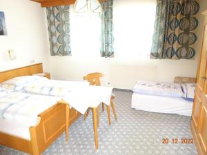 Zimmer mit 2 Betten und einem Tisch in der Unterkunft Haus Anna in Tux