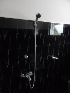 y baño de azulejos negros con ducha. en Mount View Villa Resort Mirissa, en Mirissa