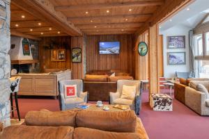 sala de estar con sofá, sillas y mesa en Hôtel L'Aiguille Percée, en Tignes