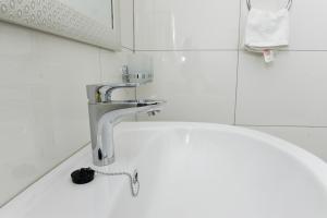 a sink in a bathroom with a faucet at Eric Wilkins Apartments in Kampala
