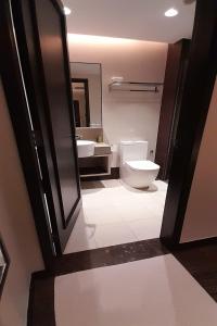 a bathroom with a toilet and a sink and a mirror at Lion Peak Hotel Hamilton in Singapore