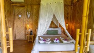 a bedroom with a bed with a canopy at Elang Hillside Bamboo Villas in Labuan Bajo