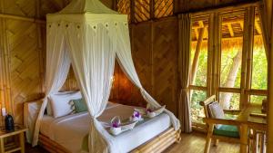 a bedroom with a bed with a canopy at Elang Hillside Bamboo Villas in Labuan Bajo +37 photos