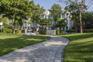 a walkway in a park with a building in the background at STAY BY LATINEM Luxury 1BR Holiday Home OPA 802 near Burj Khalifa in Dubai