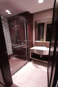 a bathroom with a sink and a shower at Lion Peak Hotel Hamilton in Singapore