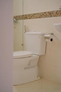 a white bathroom with a toilet and a sink at Anh Truc House - Near Front Beach in Vung Tau