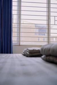 a bed with two pillows in front of a window at Anh Truc House - Near Front Beach in Vung Tau