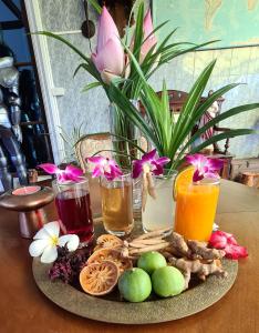un plato de comida y bebida en una mesa con flores en Beautiful bungalow with a communal outdoor pool and 2 km from the sandy beach, en Ban Sa