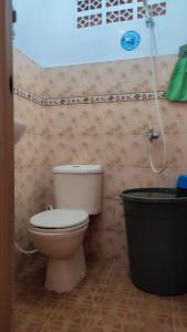 y baño con aseo y ducha. en Cendana Homestay, en Sawahlunto