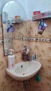 a bathroom sink with a mirror and a soap dispenser at Cendana Homestay in Sawahlunto