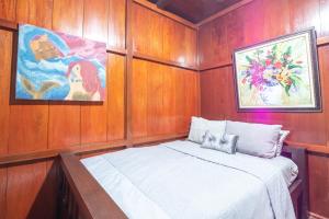 een kleine kamer met een bed in een boot bij rumah kayu sulawesi antique in Bedugul