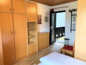 a bedroom with wooden cabinets and a bed and a window at Allgäu Appartementhaus Appartement ALLGÄU 08 in Pfronten