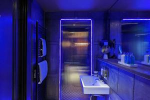 a bathroom with a sink and a shower with blue lights at The Bells - Luxury Serviced Apartments in Leeds