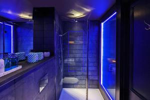a purple bathroom with a shower and a tub at The Bells - Luxury Serviced Apartments in Leeds