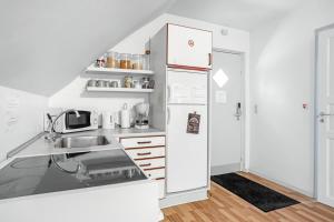 een witte keuken met een koelkast en een wastafel bij Storms Bed & Breakfast in Herning