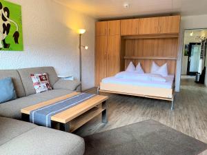 a hotel room with a bed and a couch at Appartement Frohnatur - 24 in Pfronten