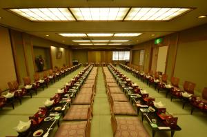 a large banquet hall with long tables and chairs at Gion Fukuzumi in Kyoto