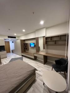 Habitación con cama, mesa y TV. en Kartepe Dedeman’da Rezidans en Kartepe